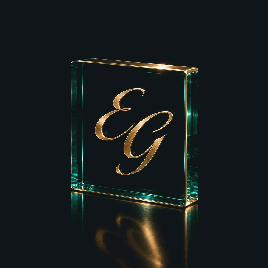 EG monogram in brushed brass inlaid in a block of deep green glass